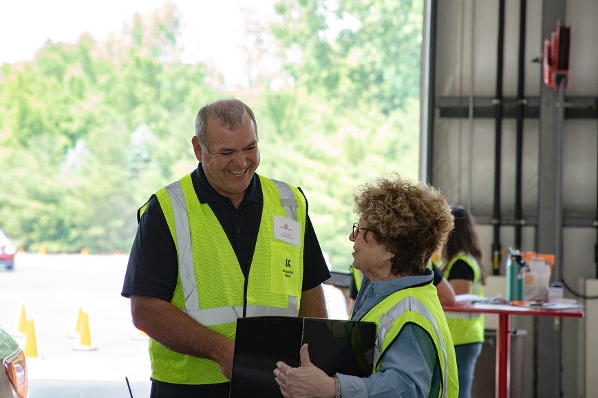 KREMC CEO Kurt Carver talks with a volunteer at the annual meeting.