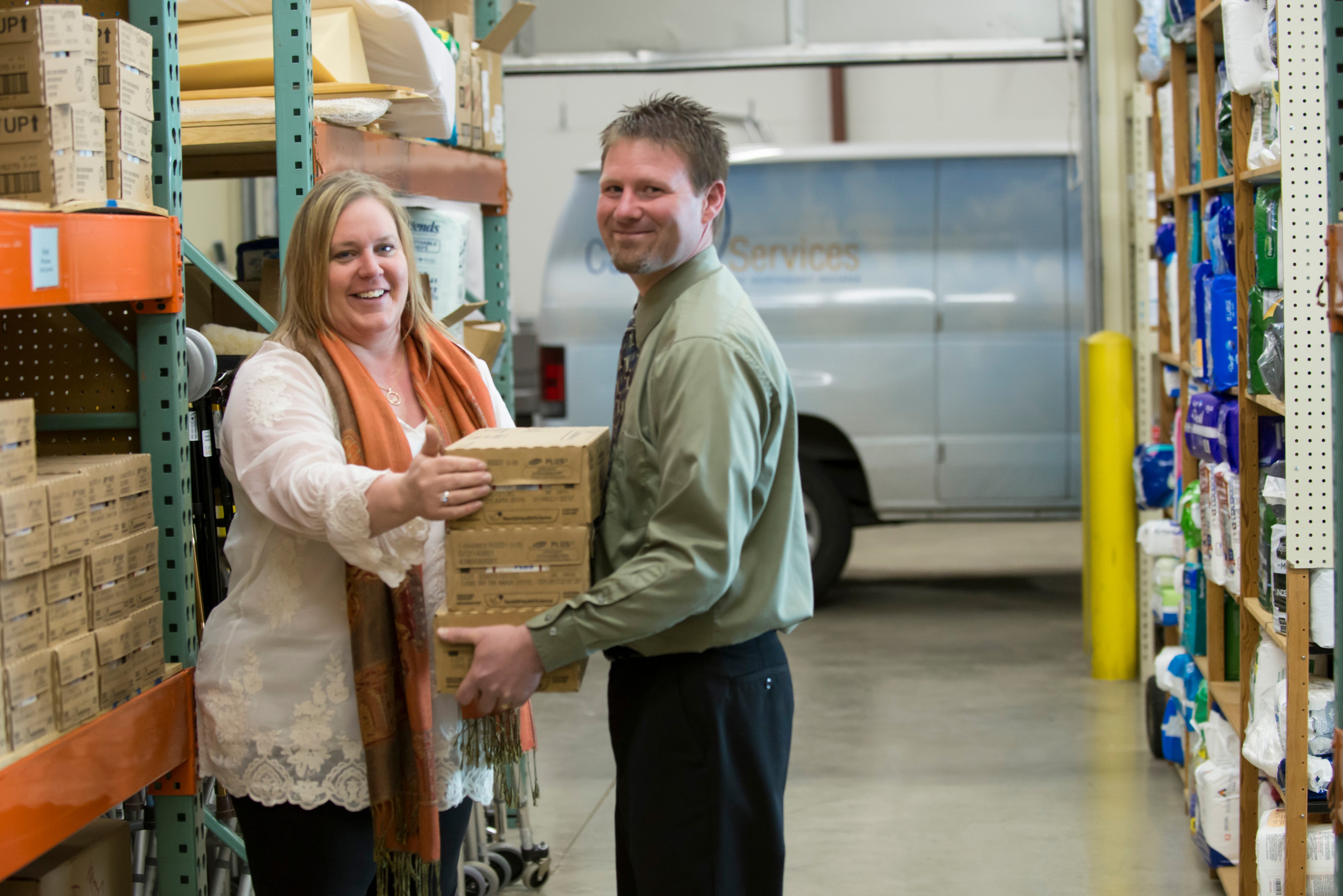 Cancer Services staff carrying equipment in warehouse