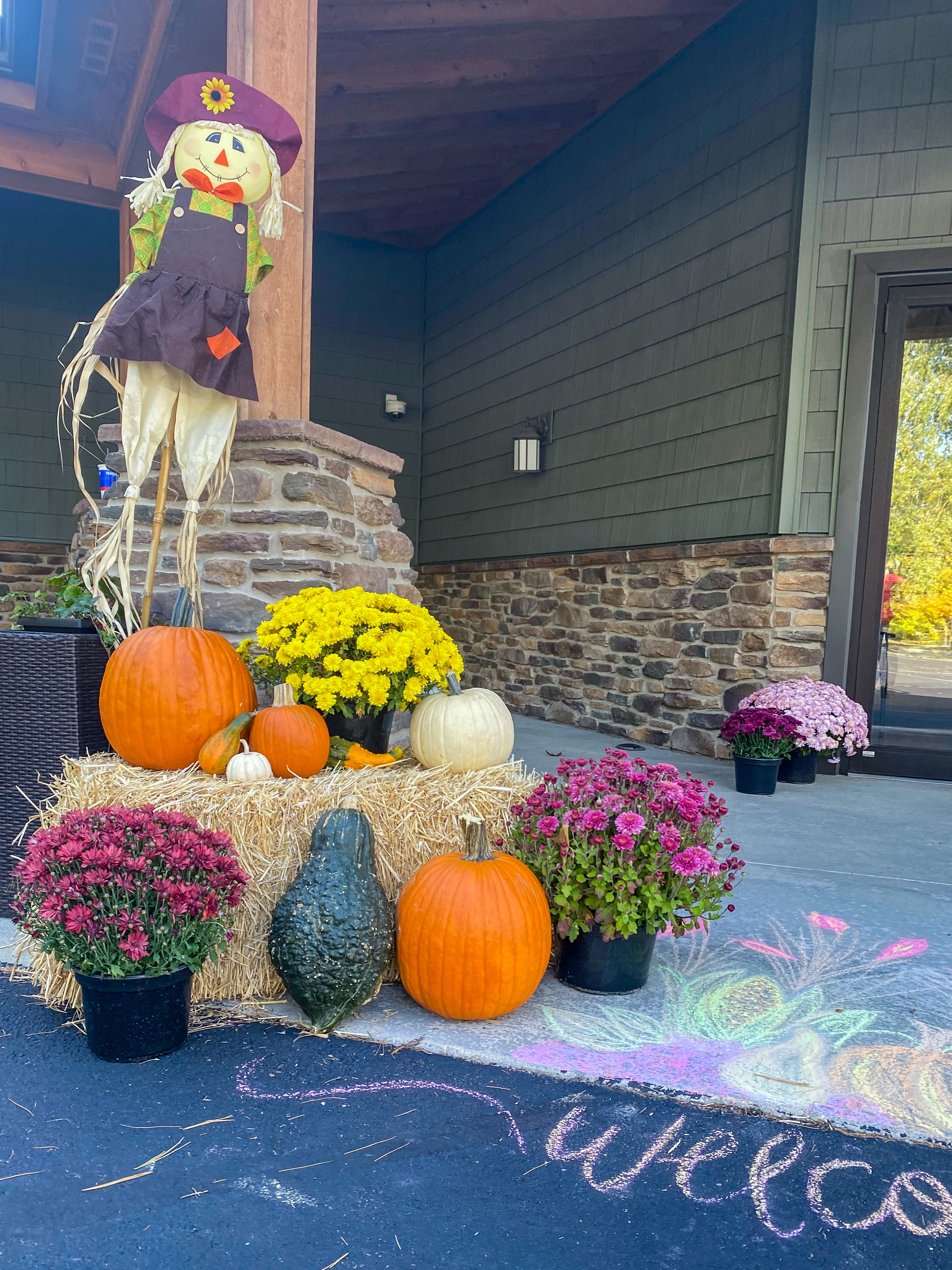 A friendly scarecrow and other decorations around the Beaman Home's front entrance