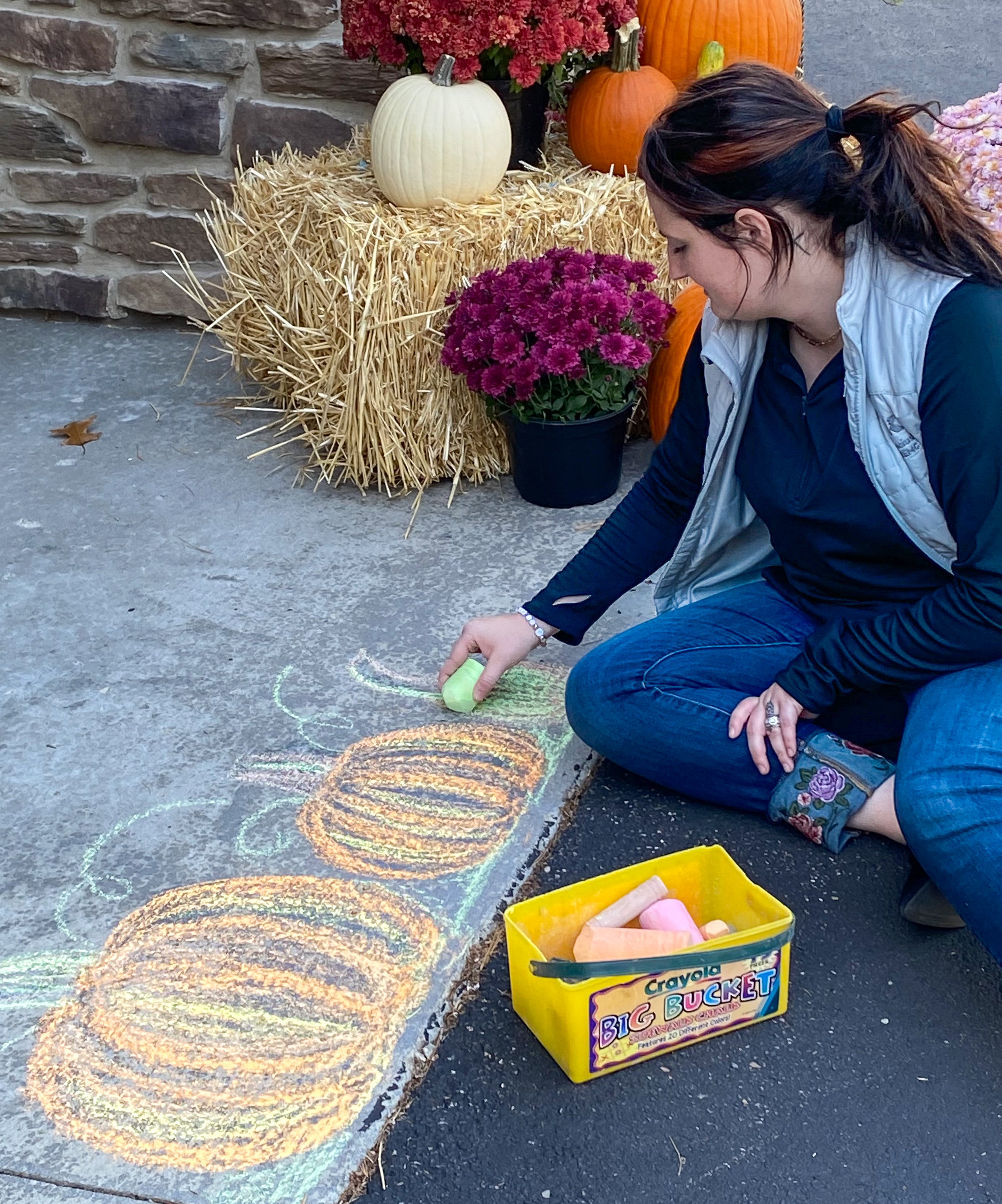 Haley Donahue draws with chalk on the Beaman Home driveway