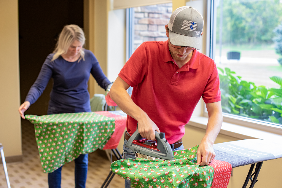 KREMC employees iron and package pillowcases on Cooperative Community Day