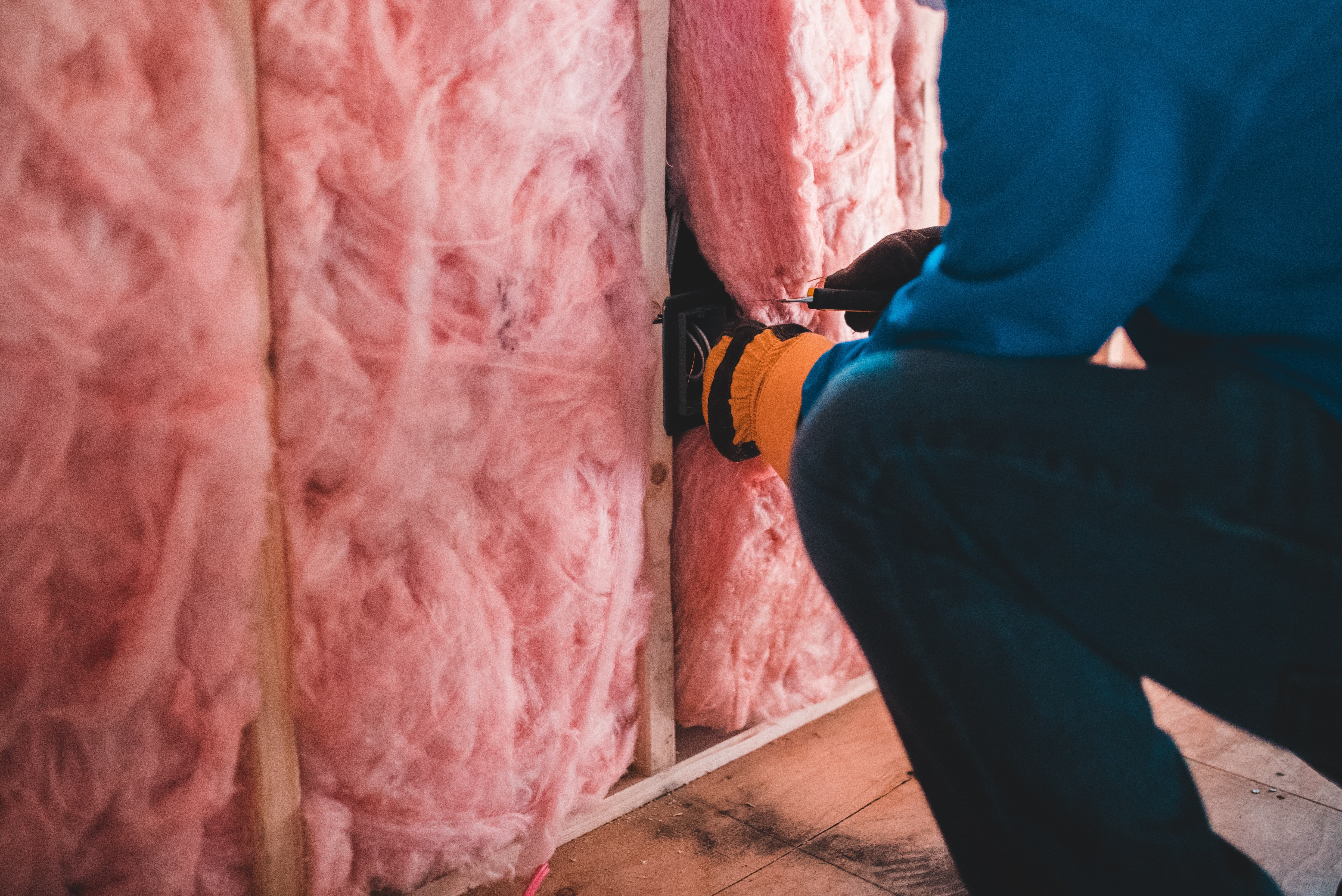 Gloved hands checking home insulation