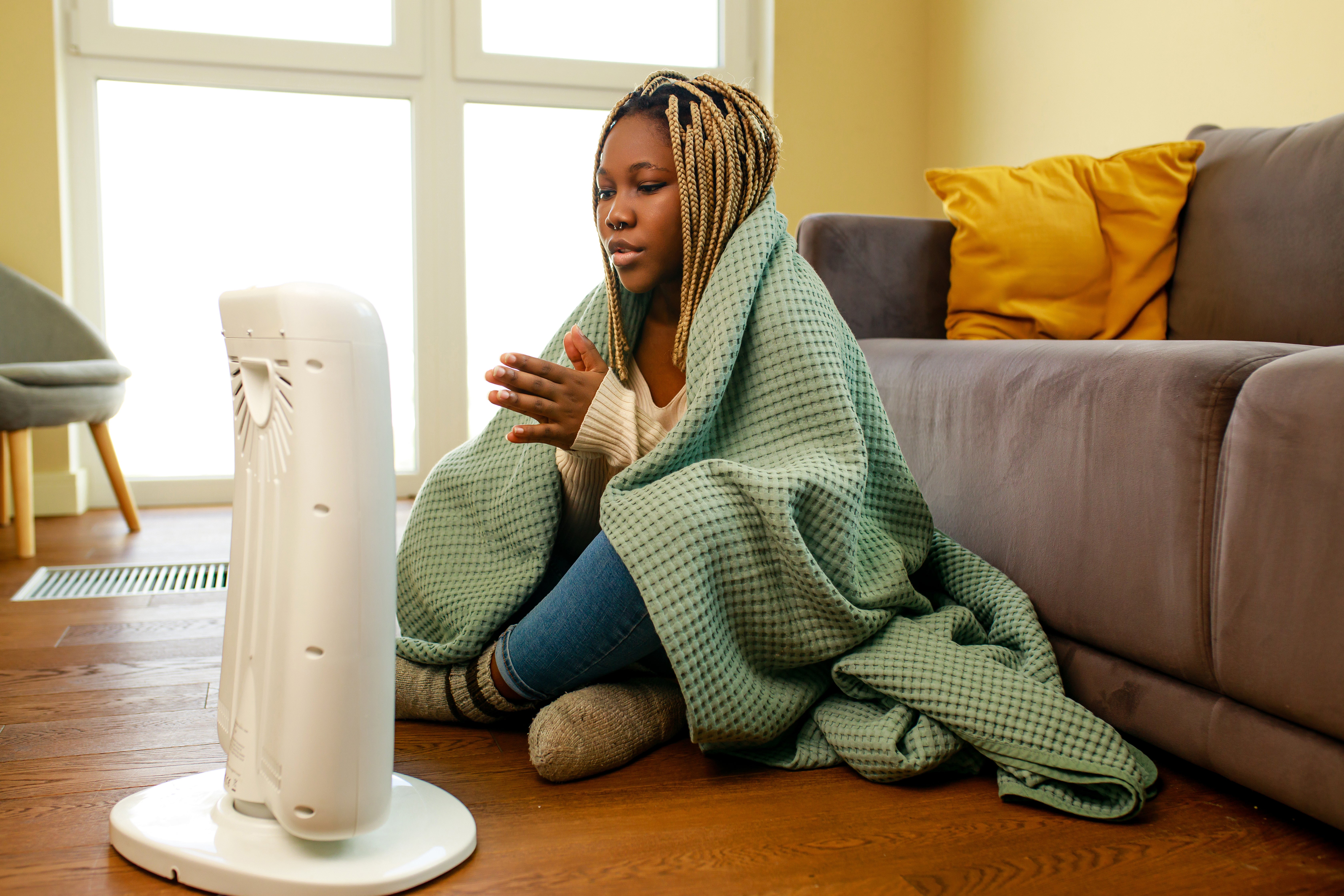 Woman warming up by space heater