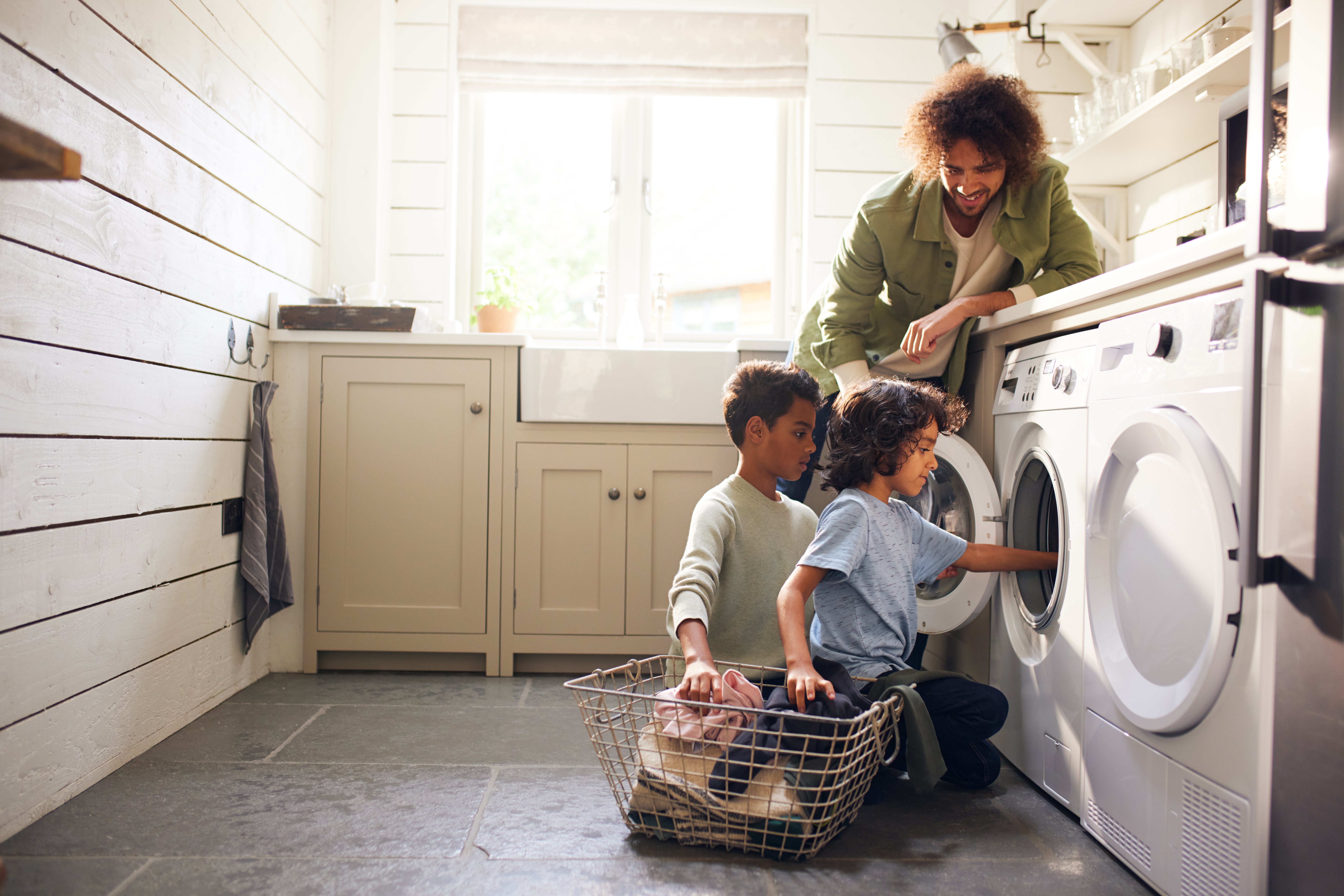 Father doing laundry with two boys
