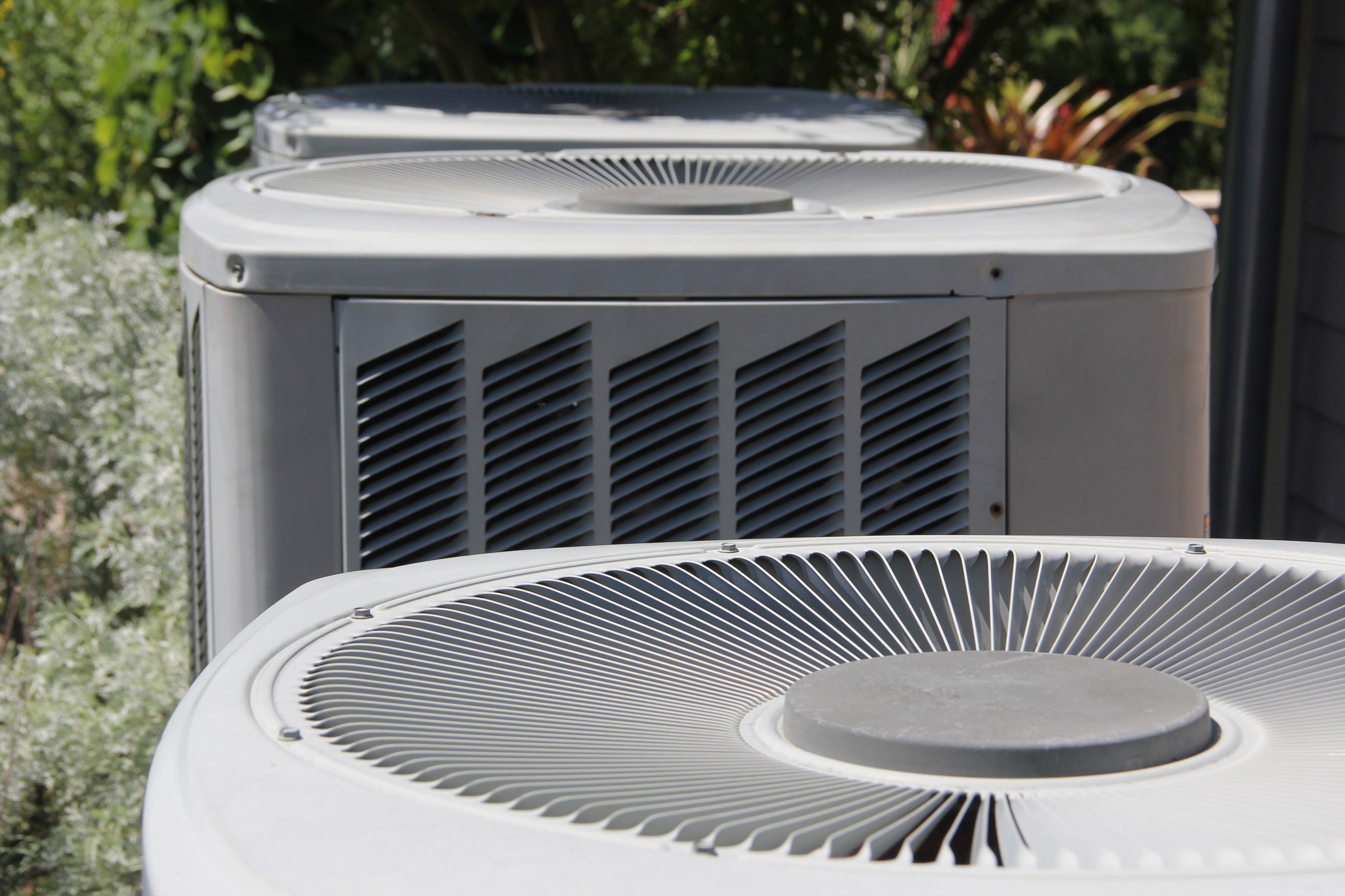 An HVAC air conditioning unit is pictured outside of a home.