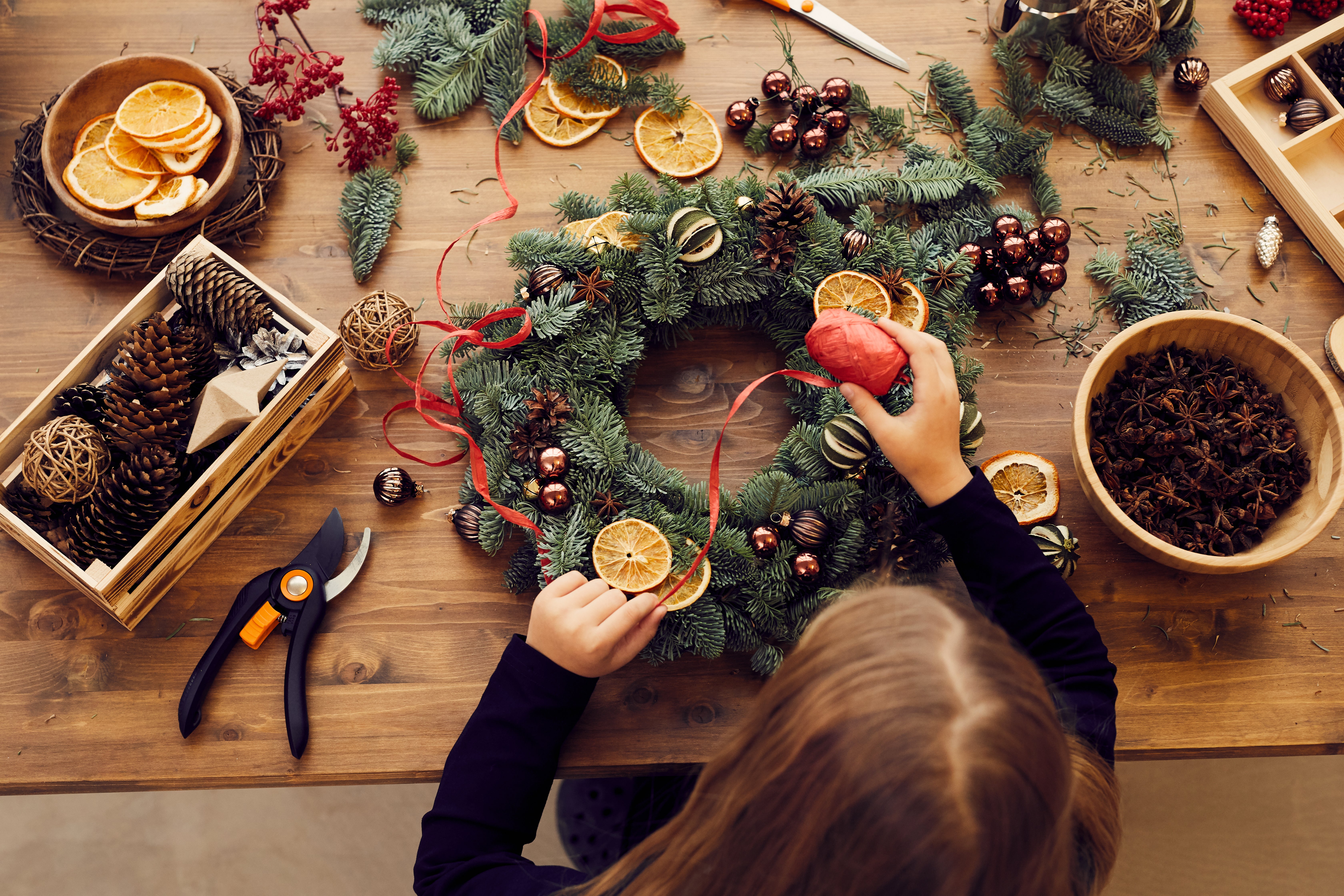 Woman's hands putting together homemade Christmas wreath