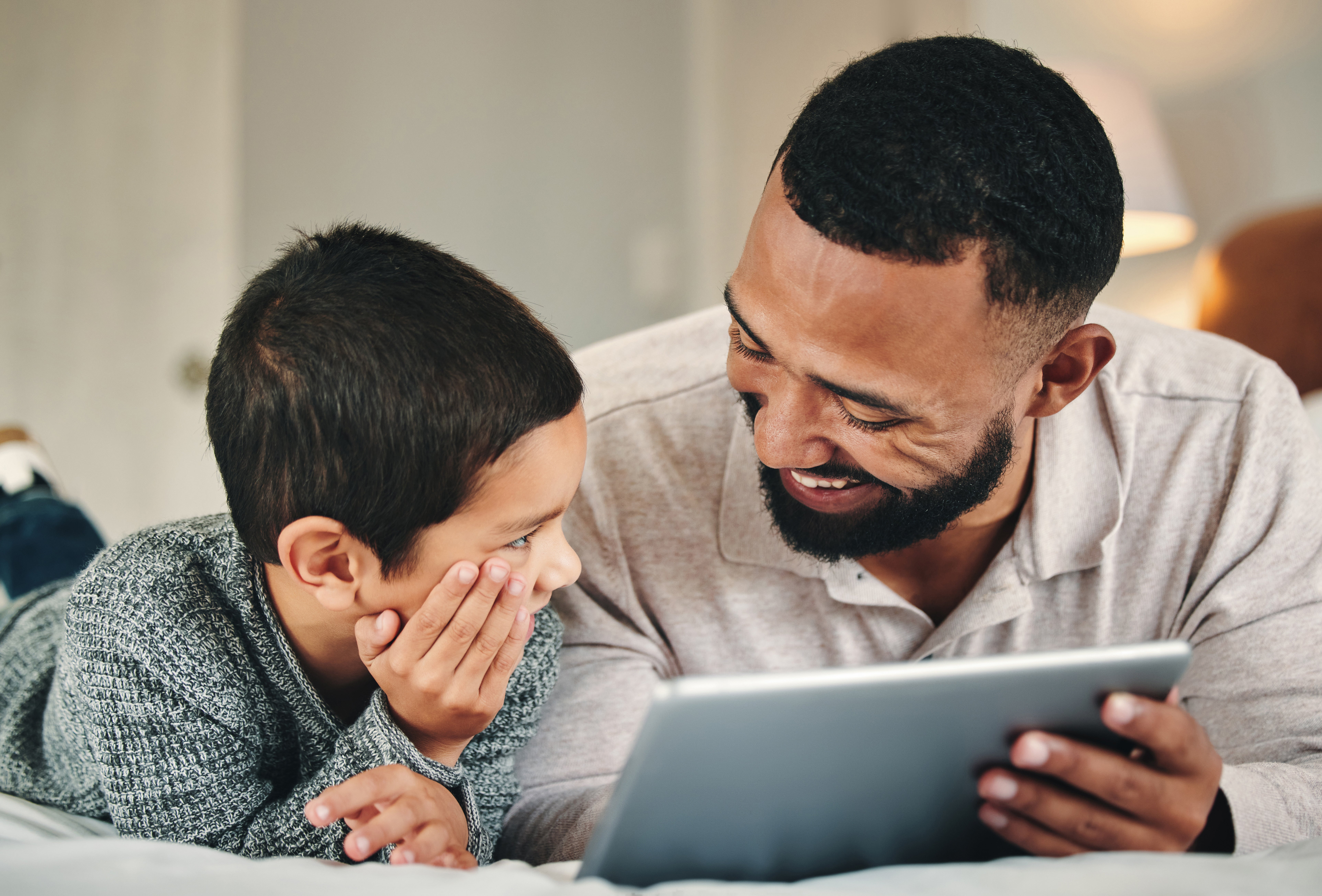 Father and son learning on tablet together