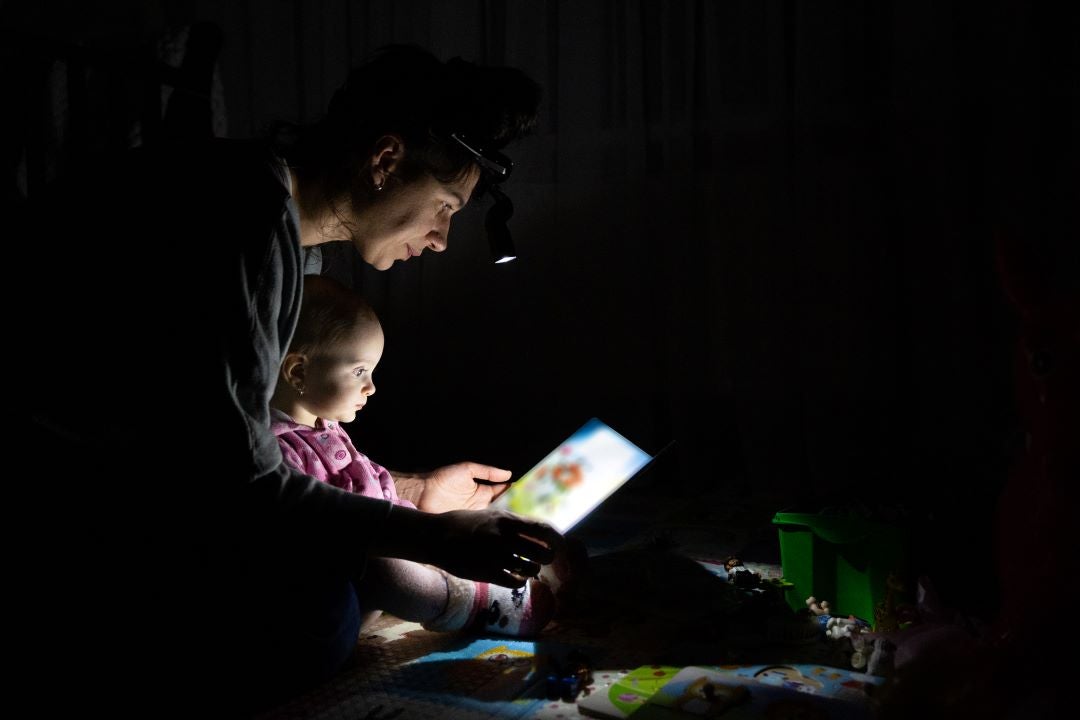 Woman reading to baby by flashlight