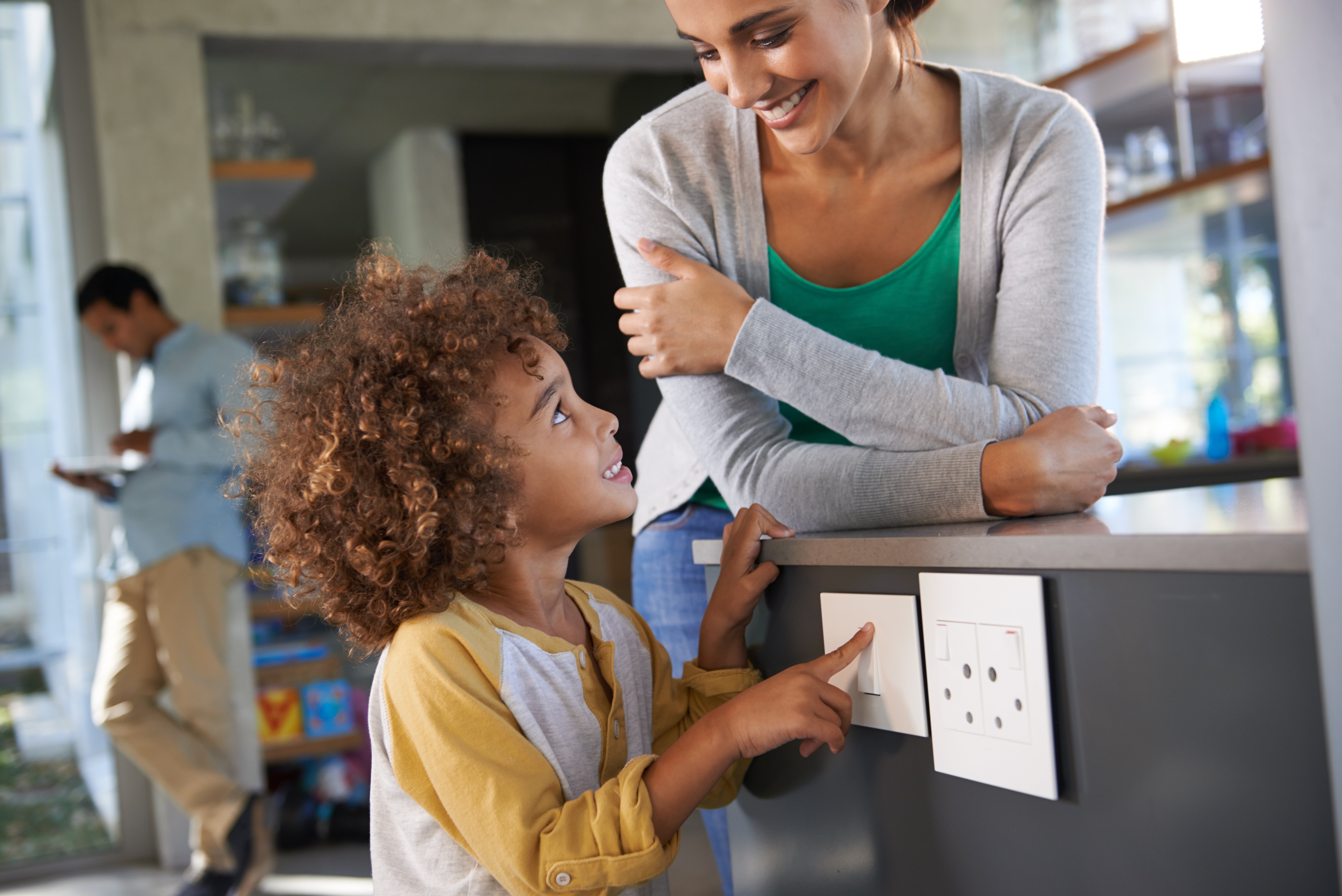 Mother watching child flip electric switch safely