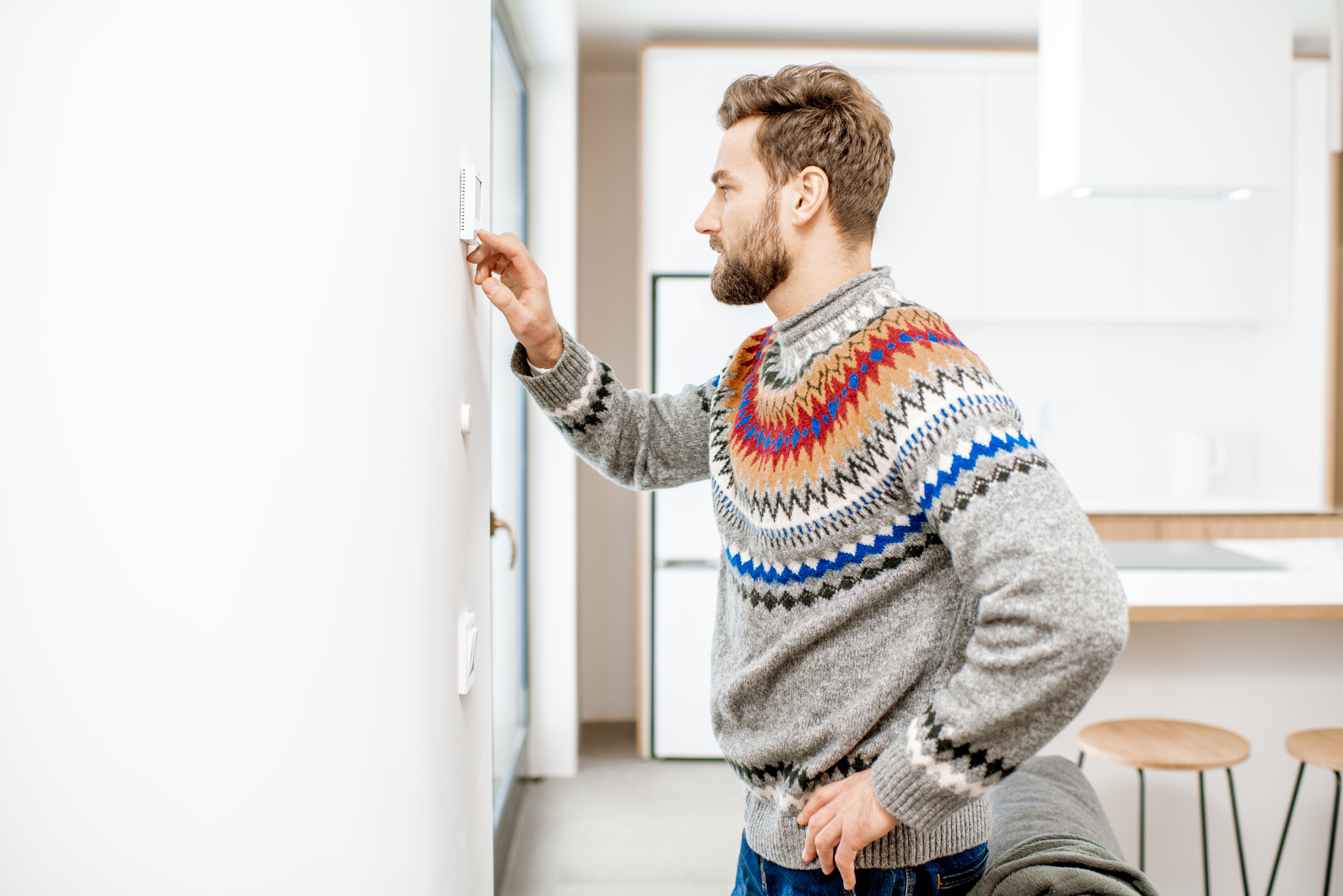 Man adjusting his home's thermostat