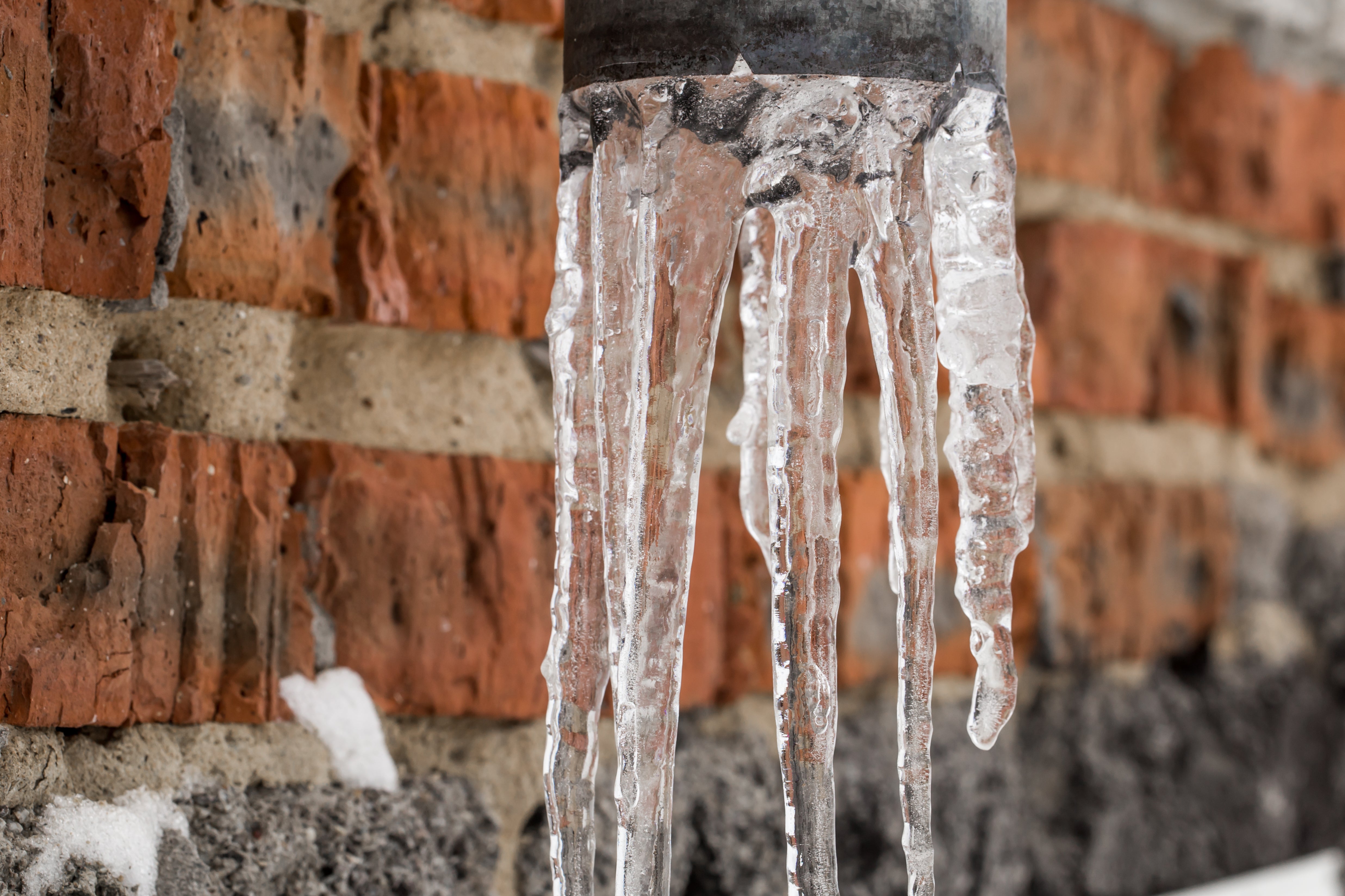 Icicles hanging off of pipe