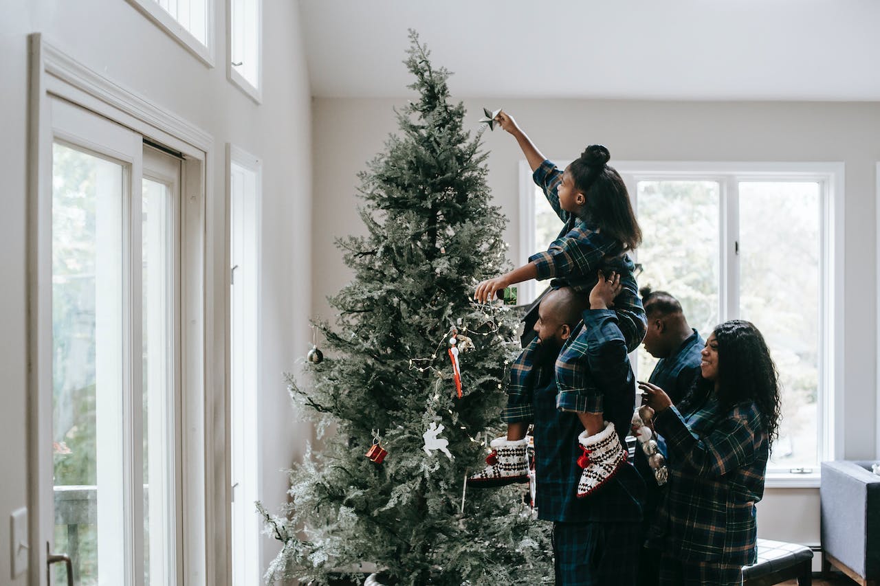 A family decorates a Christmas tree