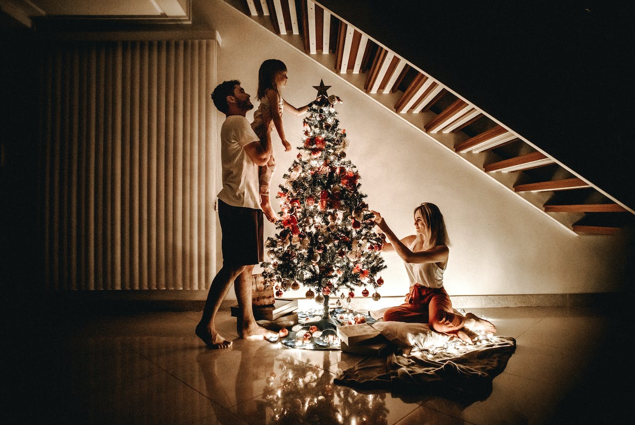 A family decorates a Christmas tree