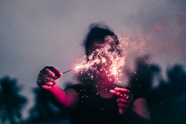 A person holds a sparkler in their hand.