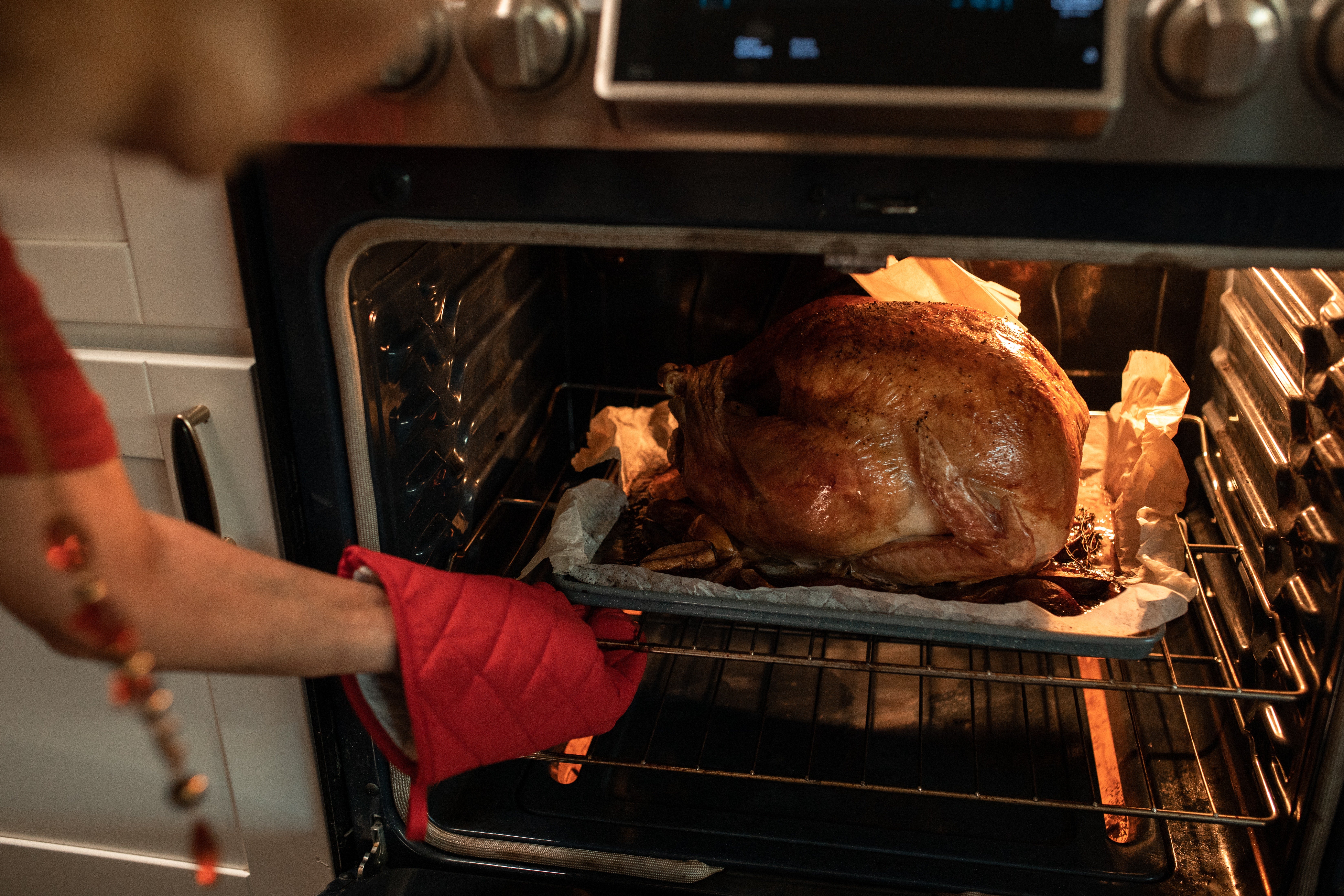 Hands taking Thanksgiving turkey out of oven