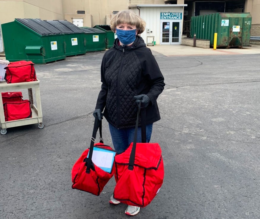 Senior Services staff member carrying home delivered meals