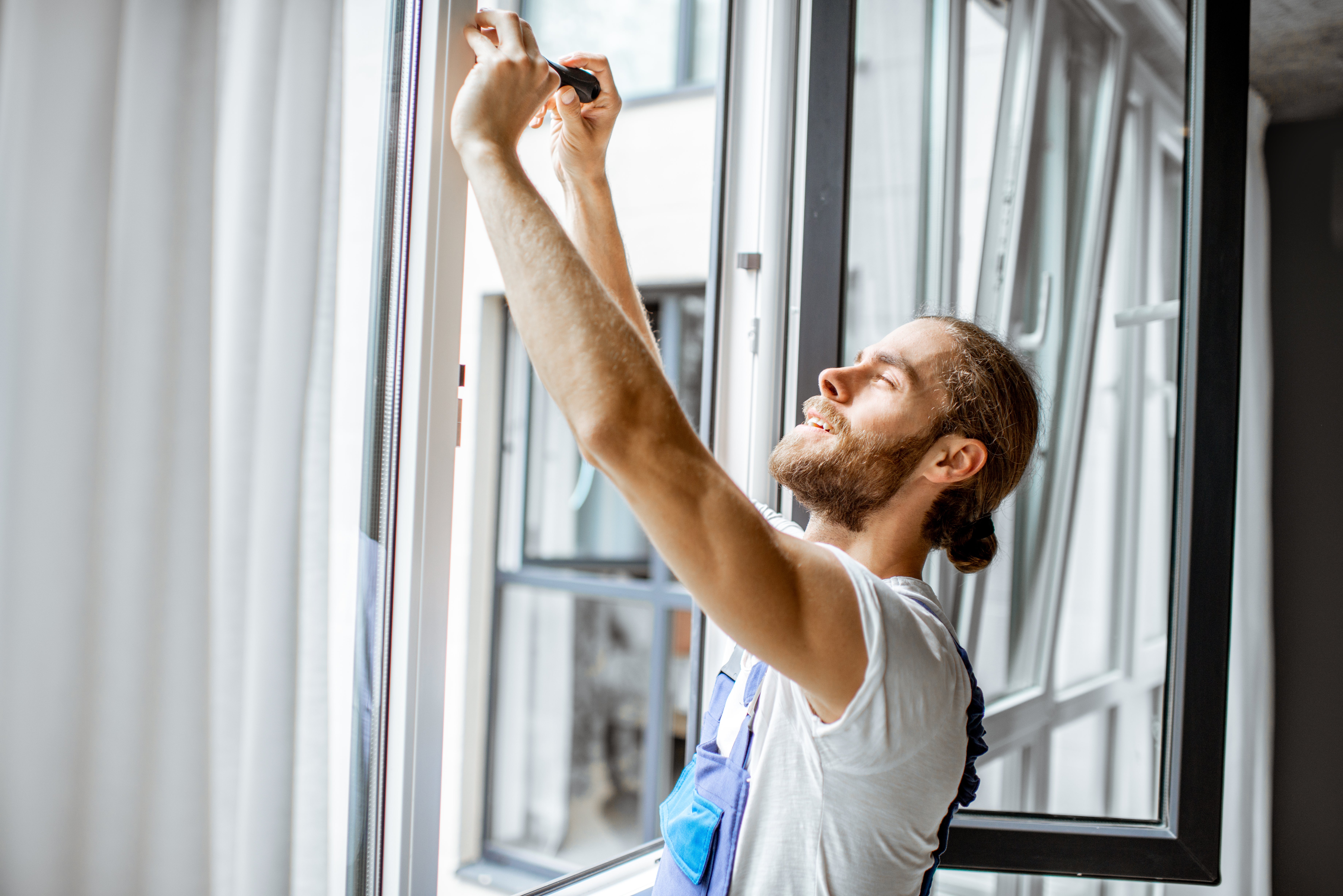 A man works on repairing a window.